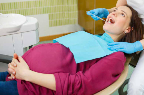 donna gravida su poltrona del dentista