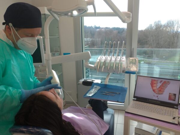 dentista mentre prende impronta digitale a una paziente a Lecco